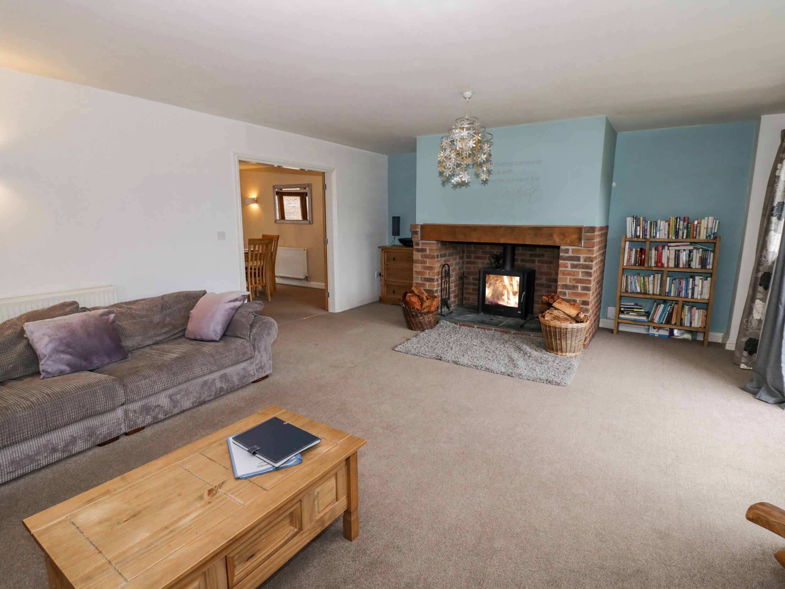 A living room with a fireplace, a sofa, a coffee table, and a bookshelf.