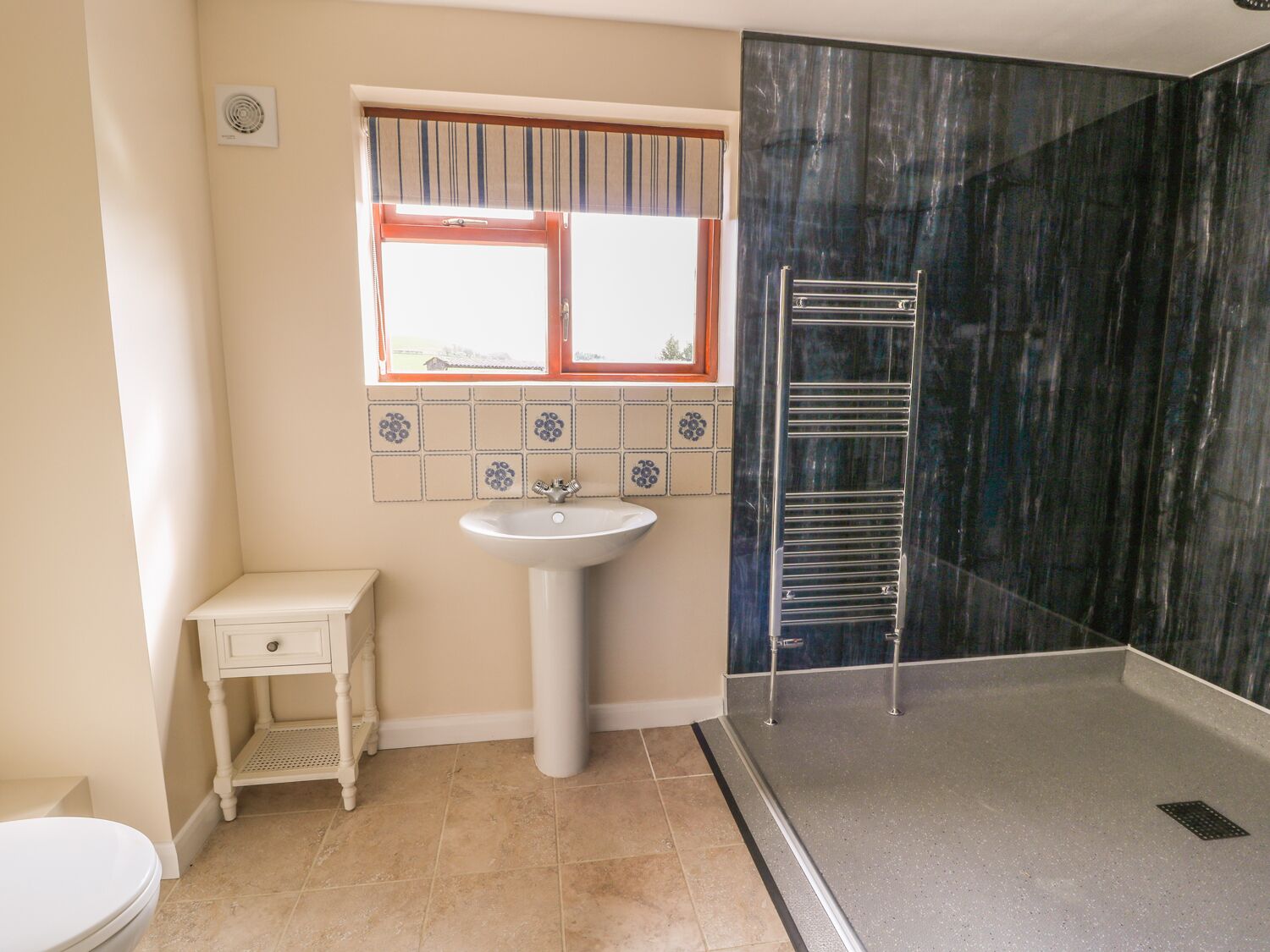 A bathroom with a toilet, sink, and shower area.