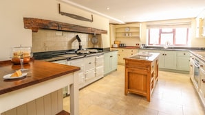 A spacious kitchen with a central island, a built-in stove, and a large window providing natural light.
