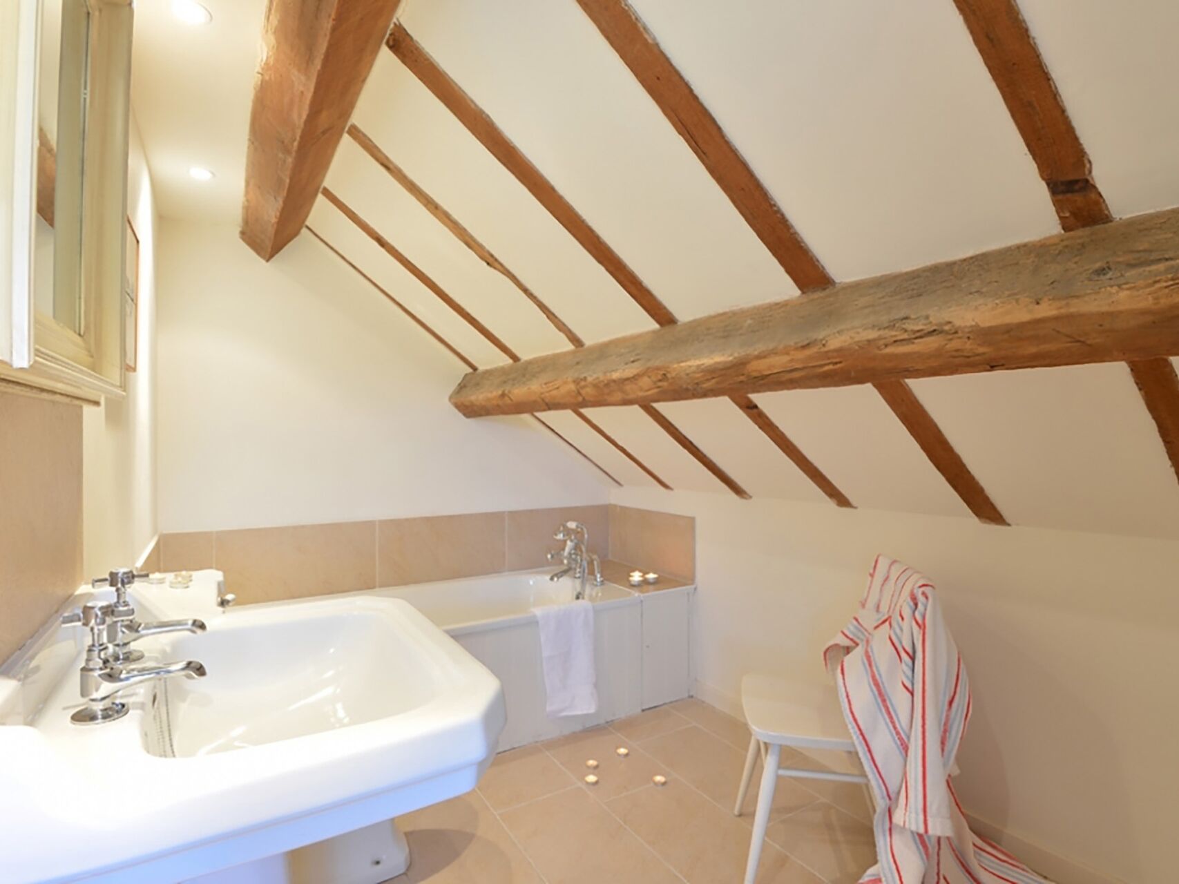 A bathroom with a large sink, a bathtub, and a mirror.