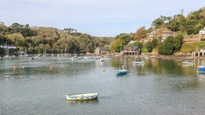 Un port tranquil amb embarcacions i una barca fondejada a prop de la riba.