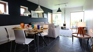 Un salon moderne comprenant un coin repas, un canapé et une table dressée pour le petit-déjeuner.