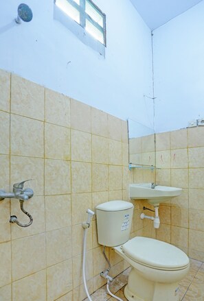 Une salle de bain équipée de toilettes, d’un lavabo et d’une douche.
