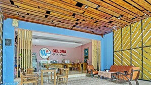 Un interior acogedor con una mesa de recepción, mobiliario de madera y suelo de baldosas.