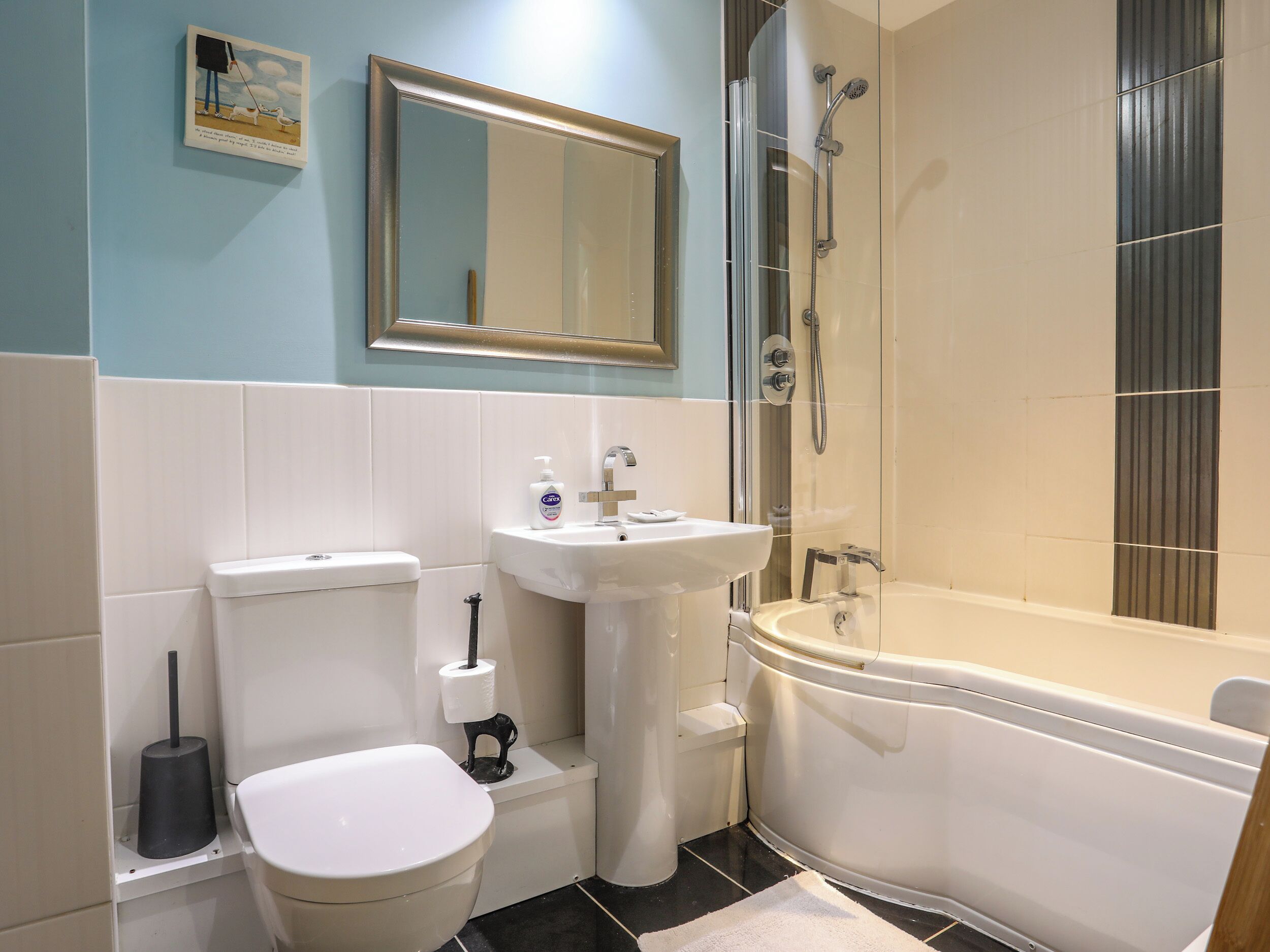 A bathroom with a toilet, sink, and bathtub.