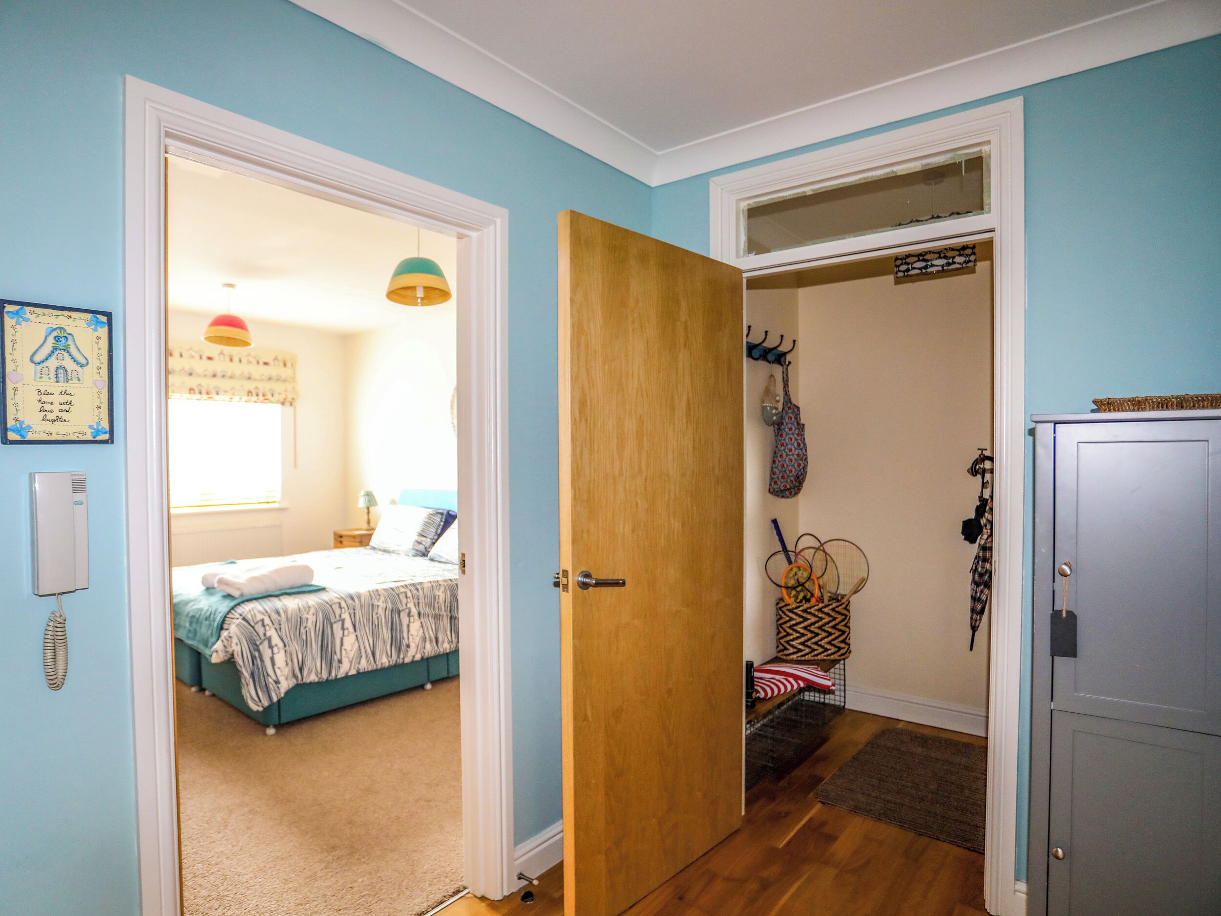 A bedroom with a bed, a bedside table, a lamp, and a window.