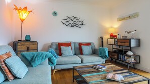 Un salon moderne avec un canapé, une table basse et une lampe.