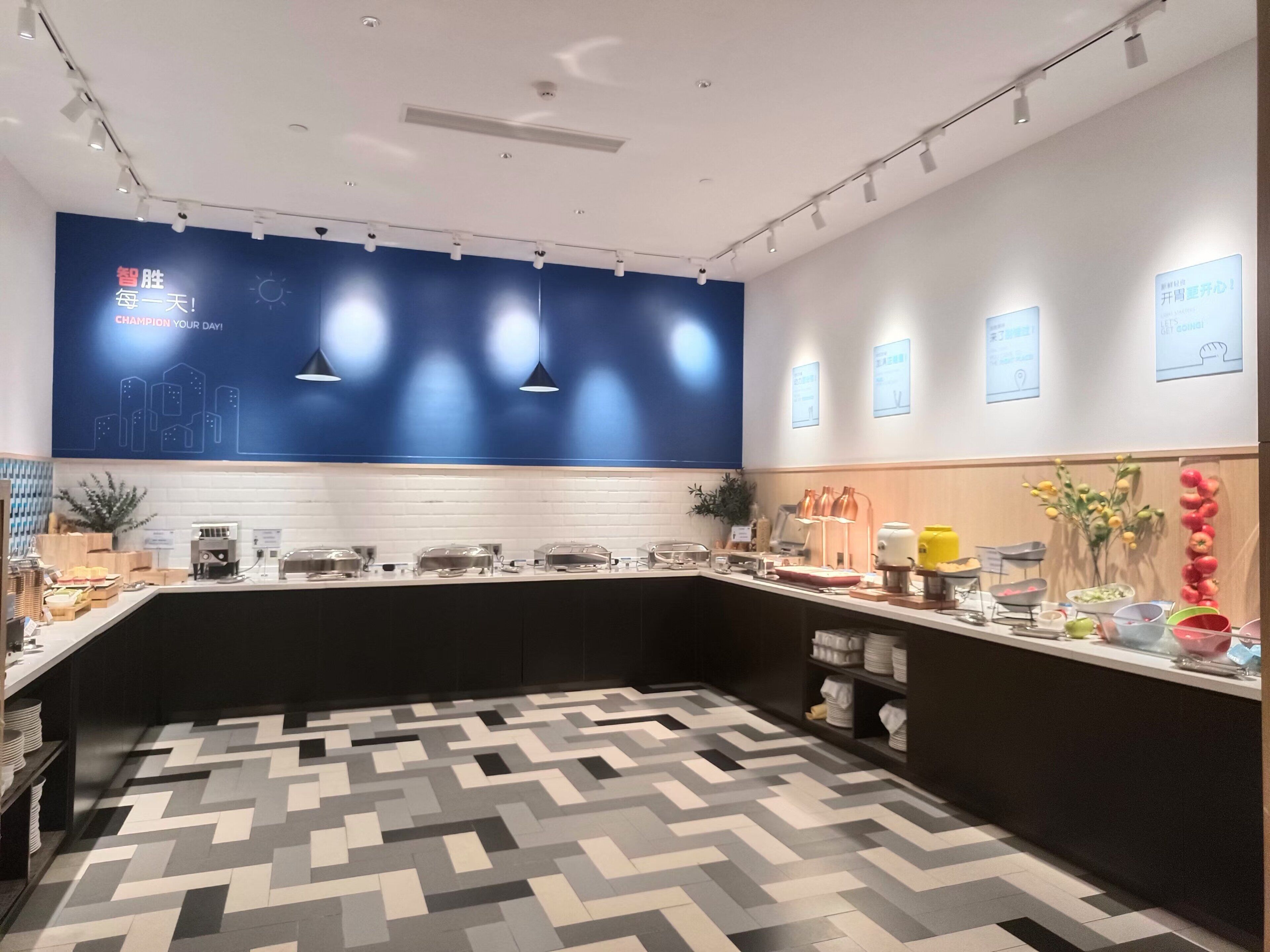 A modern kitchen with a geometric patterned floor, a blue accent wall, and various kitchen appliances and utensils.