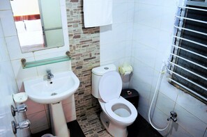 Un baño con lavamanos, inodoro y ducha blancos.