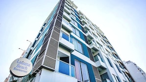 Un immeuble à plusieurs étages doté d’une architecture moderne, caractérisé par un mélange de balcons et de grandes fenêtres.