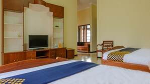 Habitación de hotel con dos camas, televisión, armario de madera y espejo.