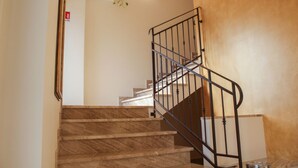 Eine Treppe mit Marmorstufen und einem Metallgeländer.