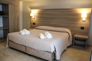 A hotel room with a large bed, two wall-mounted lamps, a wooden headboard, and a small bedside table. - La Giummara Rooms (Salemi)