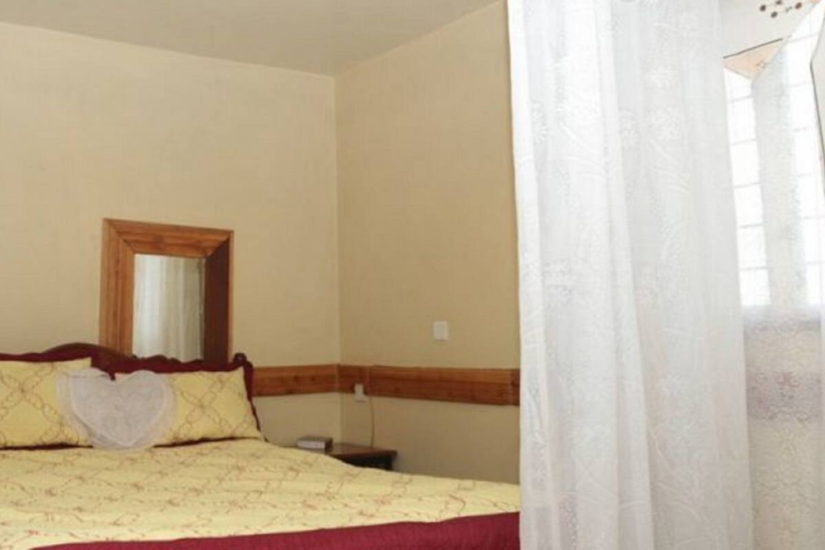 Un dormitorio con una cama, una mesita de noche y un espejo en la pared.