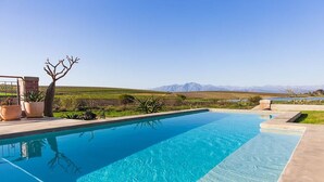 A swimming pool with a clear view of mountains in the background. - Vineyard Views Country House (Riebeek Kasteel)