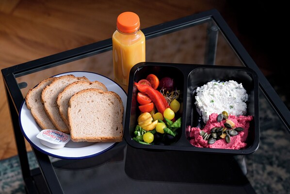 A meal with bread, a salad, and a container with rice and a pink spread on a glass table. - Native Apartments Augustiańska 24 (Kraków)