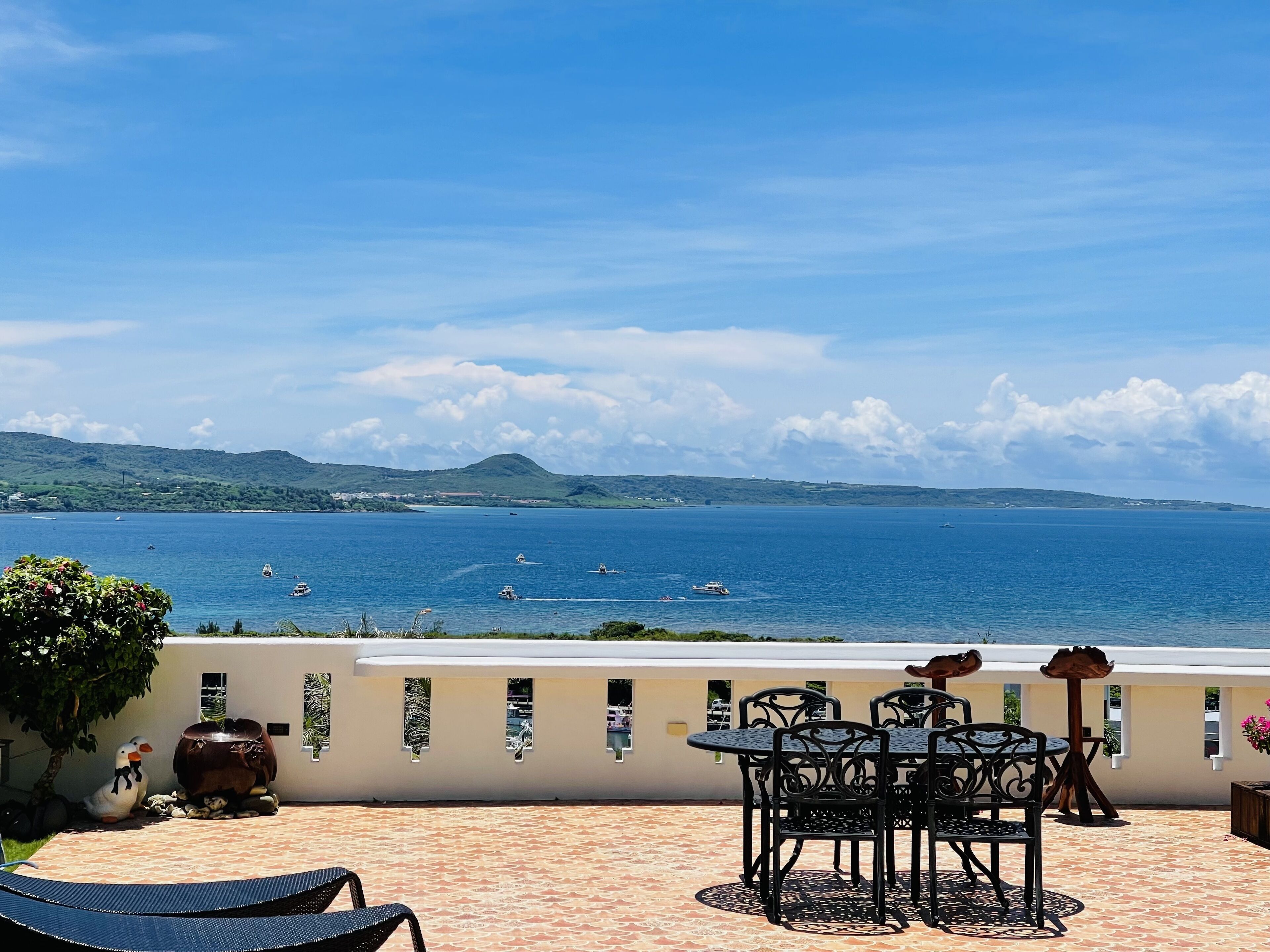 A terrace with outdoor seating and a view of the sea.