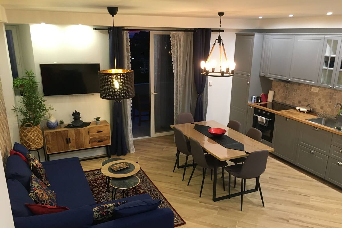 Una sala moderna con un sofá, una mesa de comedor y una zona de cocina.
