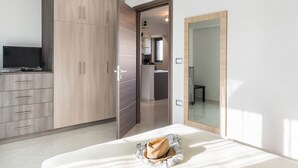 A bedroom with a bed, a wardrobe, a television, and a mirror. - Mimosa Cozy & Modern Flat steps from Sandy Beach (Platanias)