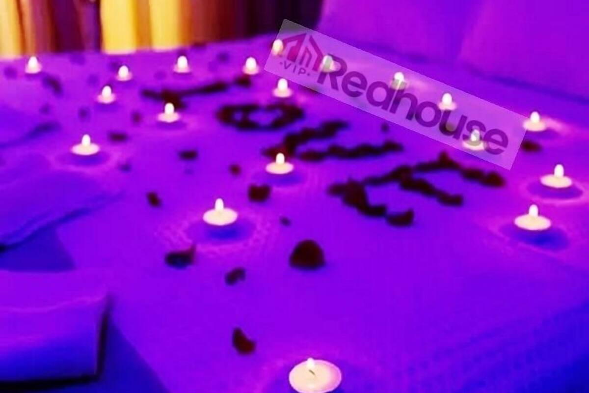 A purple-lit room with multiple candles on the floor.