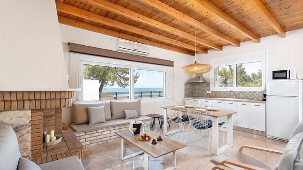 Ein modernes Wohnzimmer mit Kamin, Sitzecke und Meerblick.