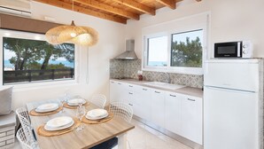 Eine moderne Küche mit weißen Schränken, Holzboden und Meerblick.