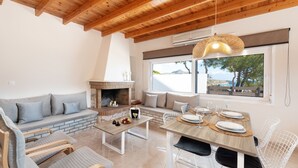 Ein modernes Wohnzimmer mit Kamin, Sitzecke und Essbereich.