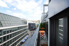 Experience the sleek, modern design of this urban hotel, featuring large windows and a stylish outdoor seating area.