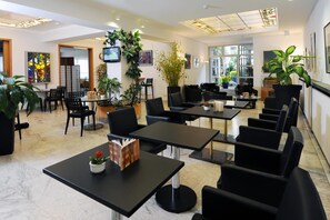 Enjoy meals and meetings in this stylish space with dining tables, comfortable chairs, and a unique ceiling design.