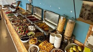 Un buffet proposant divers plats, un mur sur lequel est écrit le mot « MARE » et un panneau affichant le menu.