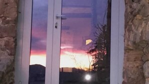 A door with a glass panel reflecting a sunset. - Typical Cevennes house for people with mountain view (Mialet)