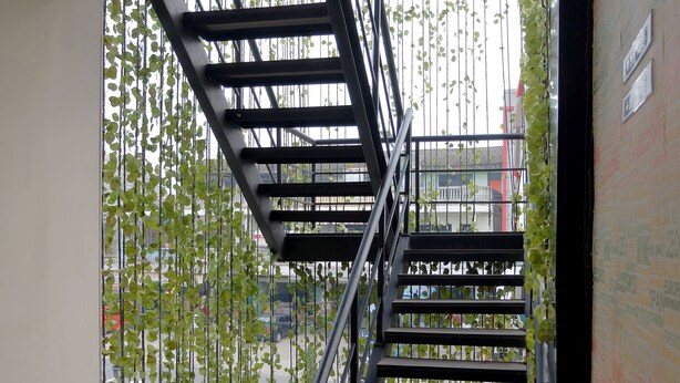 Un escalier avec des rampes en métal et un tapis rouge au bas.