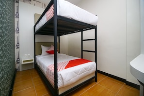 Cozy accommodation with a bunk bed, bedside table, and wall-mounted shelf, featuring a warm-toned floor and a standard sink.