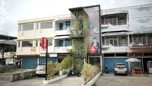 Un immeuble à plusieurs étages abritant divers commerces, notamment un centre de soins et d’esthétique, un restaurant et une concession automobile.