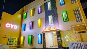 Hotel com fachada moderna, destacando uma placa grande da marca 'OYO' e a marca 'AURILA'.