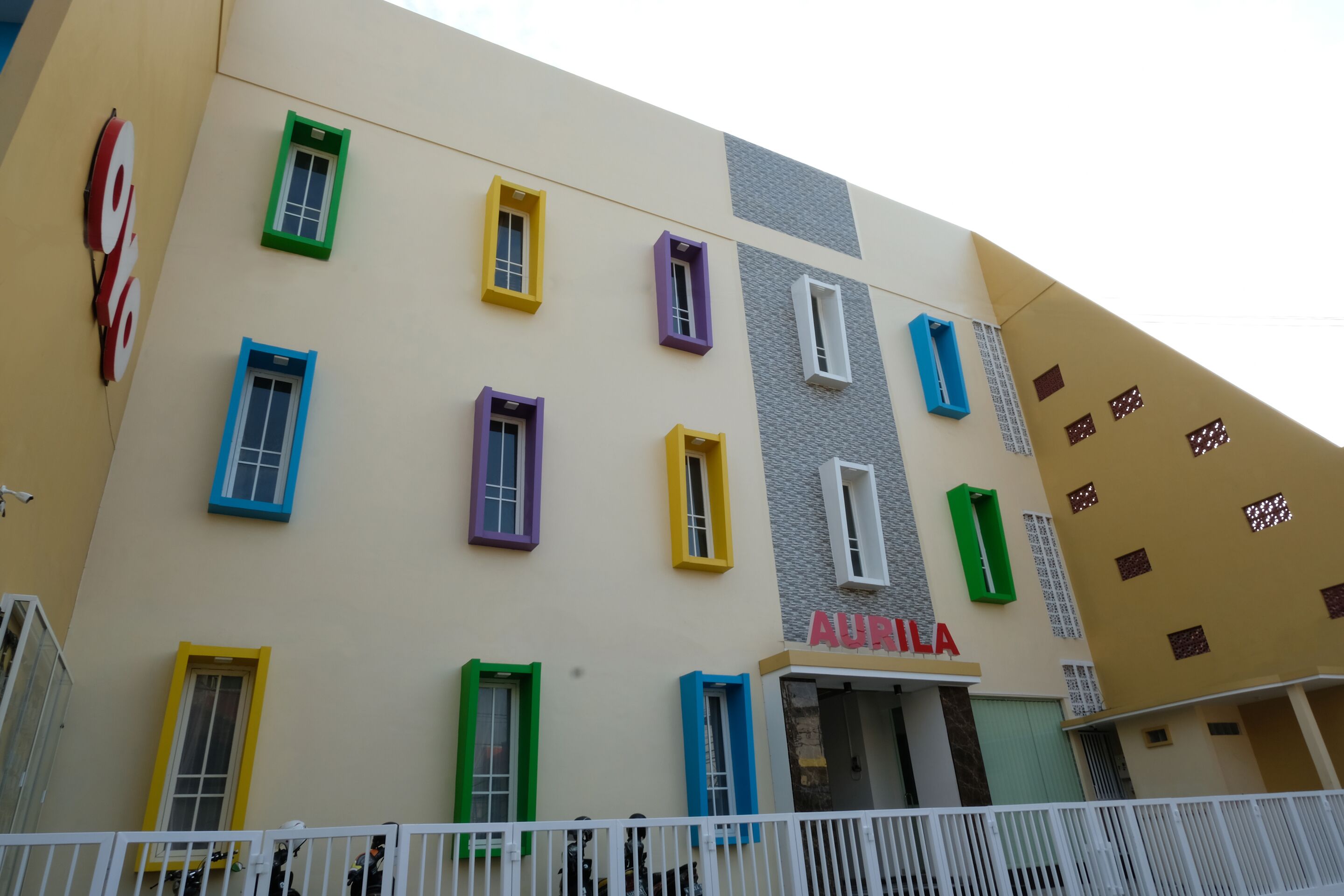 A building with multiple colorful windows and a sign that reads "AURILA".