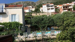 A residential area with houses, a swimming pool, and a hillside in the background. - Villa Marghareta - Deluxe App Marghareta (Dubrovnik)