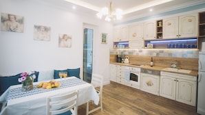 A modern kitchen with wooden cabinets, a built-in oven, and a countertop with a coffee maker. - Villa Marghareta - Deluxe App Marghareta (Dubrovnik)