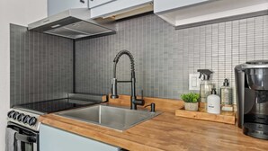 A modern kitchen with a stainless steel sink, a built-in oven, and a coffee machine. - Downtown Aspen Studio | Walk to Gondola & Slopes (Aspen)