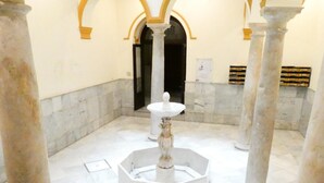 A marble-floored atrium with a central fountain, flanked by columns, and an arched doorway in the background. - Studio with terrace next to the Atarazanas Market by Málaga Planners (Málaga)