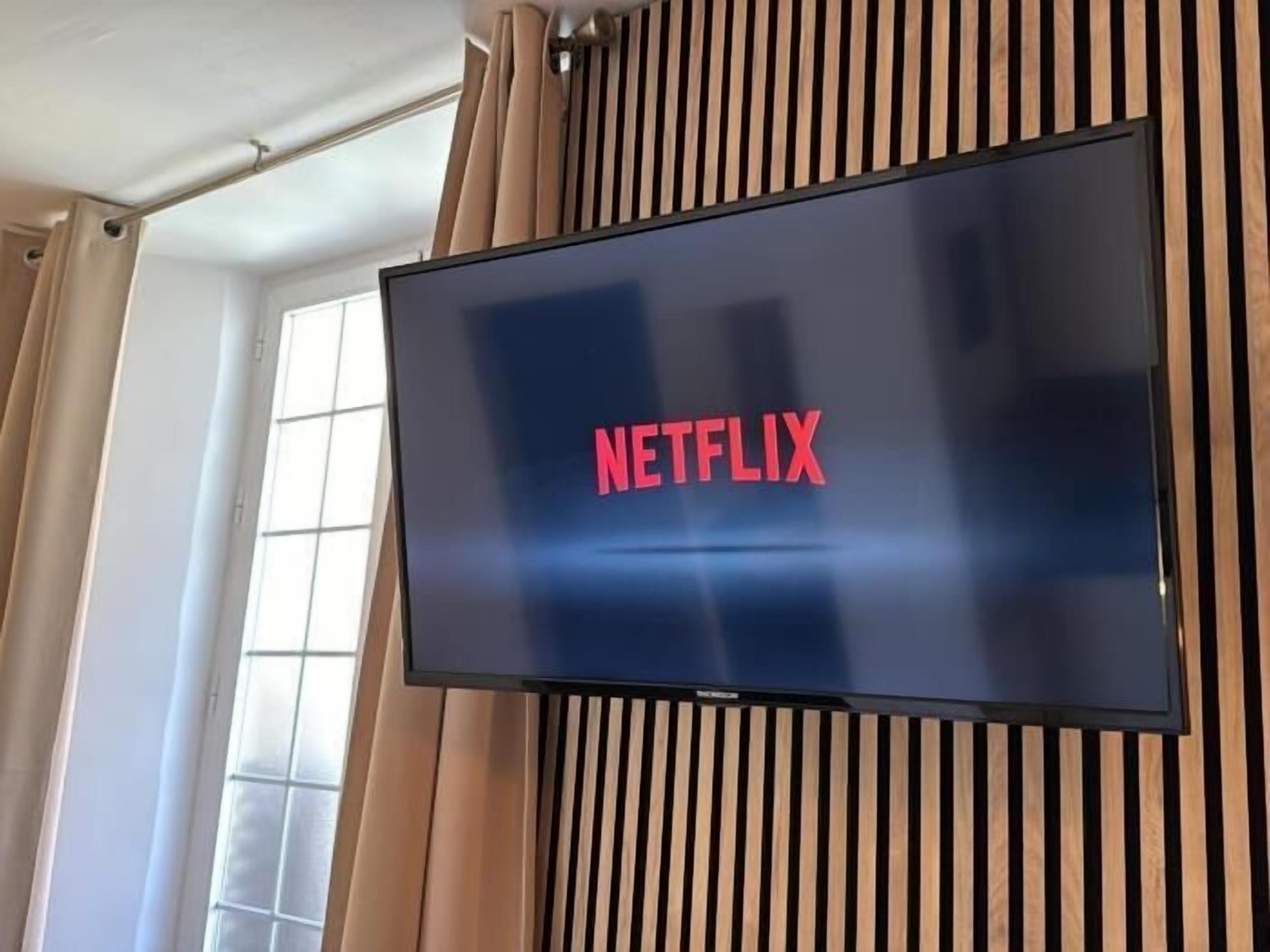Ein an der Wand befestigtes Fernsehgerät, auf dem das Netflix-Logo zu sehen ist.