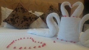 A bed with decorative pillows, a heart-shaped arrangement of towels, and a swan-shaped towel on a hotel bed. - Hotel Asliya Regency (Mawathagama)