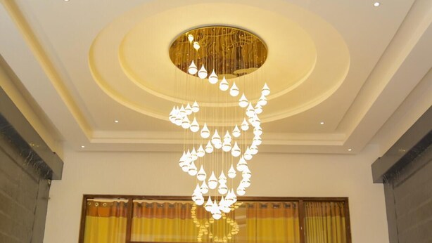A modern interior with a unique chandelier design, large windows with yellow curtains, and a clean, minimalist ceiling. - Hotel Asliya Regency (Mawathagama)