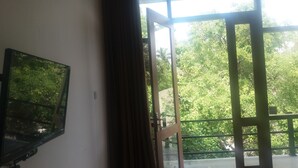 A room with a large window, a curtain, and a framed picture on the wall. - Hotel Asliya Regency (Mawathagama)