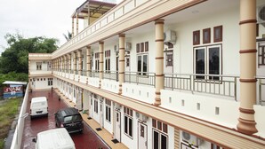 A multi-story hotel with a covered outdoor area, multiple balconies, and a red brick ground floor. - Hotel O Sopou Penginapan Rinal & Tuah (Bahapal Raya)