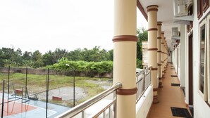A corridor with beige pillars and a glass balcony. - Hotel O Sopou Penginapan Rinal & Tuah (Bahapal Raya)