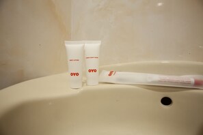 A bathroom sink with two OYO body lotion tubes and a tube of OYO hair and body wash. - Hotel O Sopou Penginapan Rinal & Tuah (Bahapal Raya)