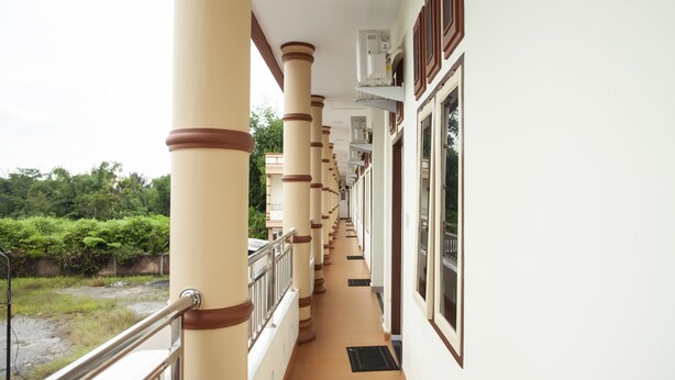 A corridor with columns and railings, leading to a door with a window. - Hotel O Sopou Penginapan Rinal & Tuah (Bahapal Raya)