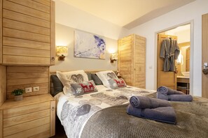 Experience a cozy retreat with a large bed, wooden cabinetry, and elegant lighting.