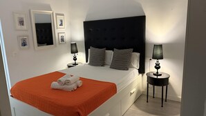 Een moderne hotelkamer met een groot bed, twee nachtkastjes en een hoofdbord.